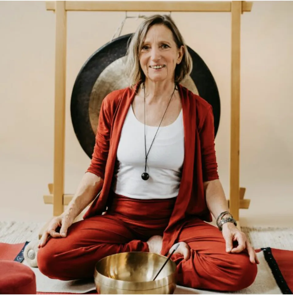 Andrea Schön mit Klangschale vor einem Gong